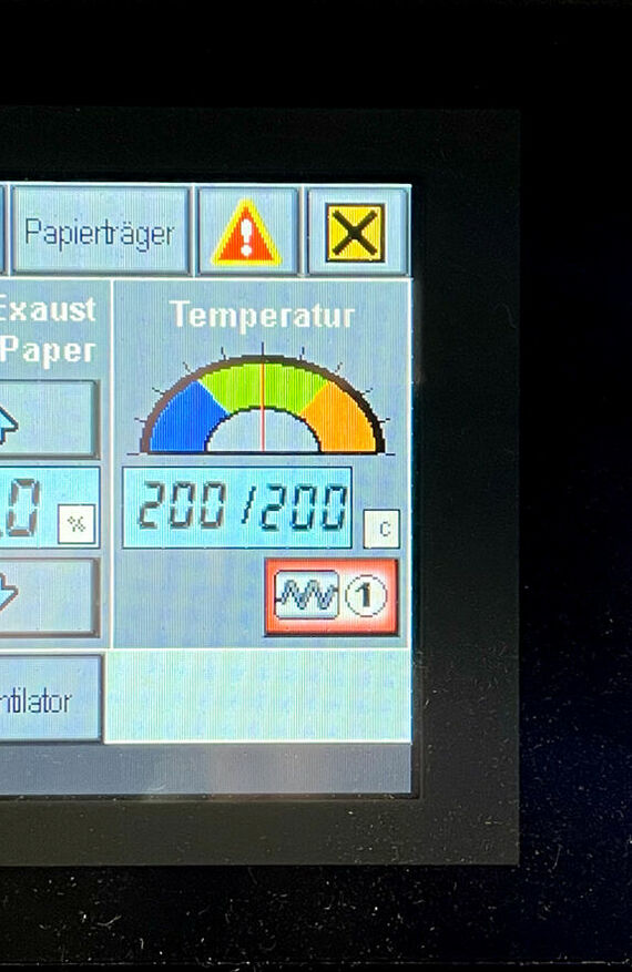 Digitaldisplay mit verschiedensten Einstellungenswerten, eines Kalenders. Mit rotem Notausknopf und weiteren Bedienungselementen.