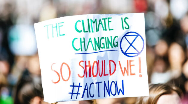 Ein Protestschild mit der Aufschrift The climate is changing so should we! #actnow