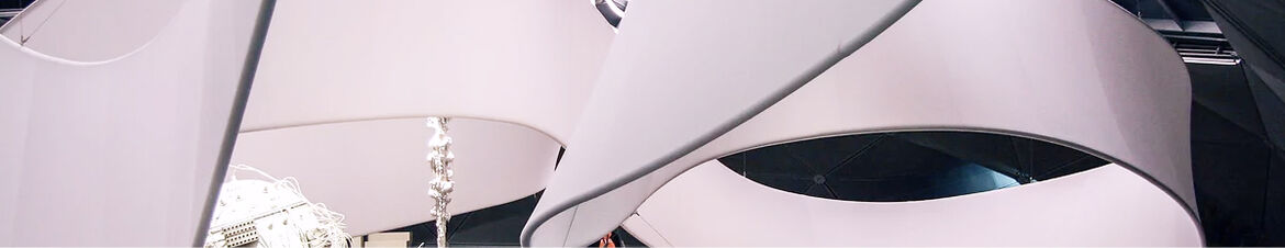 Round textile sculptures in white hang from the ceiling.
